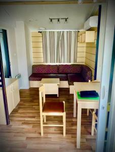 ein Zimmer mit einer Couch, einem Tisch und einem Stuhl in der Unterkunft Charmant Mobilhome in Lagrand