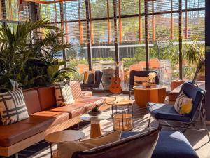 een grote kamer met banken en stoelen en een gitaar bij Ibis Lunel Petite Camargue in Lunel +82 foto's