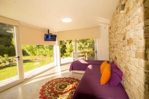 a bedroom with two beds and a stone wall at Samay Huasi - Cabañas y Casa de Te in Chapadmalal