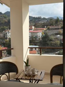 a table with two cups on top of a balcony at Aprosmeno House 7 in Agros