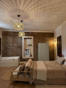 a bedroom with a large bed and a brick wall at Aprosmeno House 7 in Agros