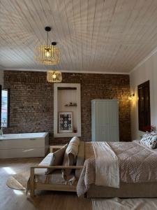 a bedroom with a bed and a brick wall at Aprosmeno House 7 in Agros +5 photos