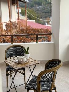 a table and two chairs with cups on a balcony at Aprosmeno House 7 in Agros