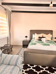 a bedroom with a large bed and a couch at Cape Comfy Hidden Home in Cravenby