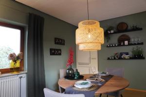 een eetkamer met een tafel en een kroonluchter bij Bühler Blick in Bühl