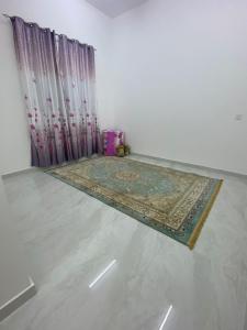 ein Zimmer mit einem Teppich auf dem Boden neben einem Vorhang in der Unterkunft Al Raha Apartments in Badīyah
