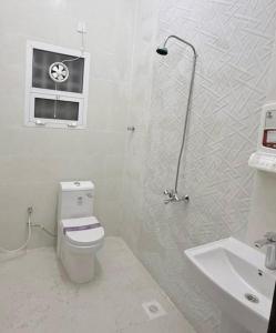 ein weißes Badezimmer mit Toilette und Waschbecken in der Unterkunft Al Raha Apartments in Badīyah