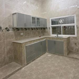 eine große Küche mit einem Waschbecken und einem Fenster in der Unterkunft Al Raha Apartments in Badīyah