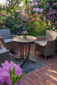 a patio with a table and chairs and flowers at Apartment Schomaker-Fatmann by Interhome in Rastdorf +5 photos
