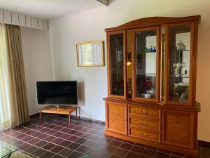 a living room with a television and a wooden hutch at Apartment Schomaker-Fatmann by Interhome in Rastdorf