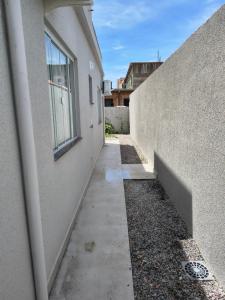 an alleyway between a building and a wall at Casa Jardim dourado in Porto Belo