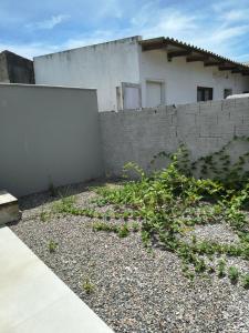 a yard with a wall and a building at Casa Jardim dourado in Porto Belo