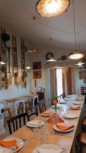 un tavolo lungo lungo con sedie, piatti e bicchieri di Viola Nel Parco a SantʼAlfio