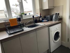 una cucina con lavello e lavatrice di 4 bed house perfect for contractors a Coseley