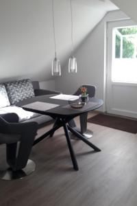 a dining room with a table and a couch at Apartment Am Wald by Interhome in Westerstede