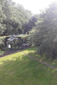 a garden with a gazebo and a green lawn at Apartment Am Wald by Interhome in Westerstede