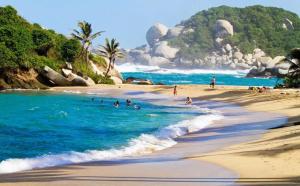 a group of people swimming in the ocean on a beach at CALABAZO Casa MonoCai in Santa Marta