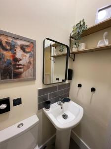 ein Badezimmer mit Waschbecken und Spiegel in der Unterkunft 4 bed house perfect for contractors in Coseley + 13 Fotos