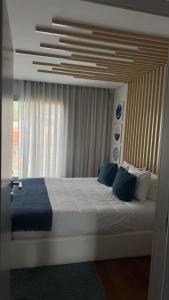 a bedroom with a large bed with blue pillows at Casa Douro in Valbom