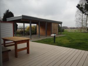 a pavilion with a picnic table and a bench on a deck at Holiday Home achtein by Interhome in Westoverledingen