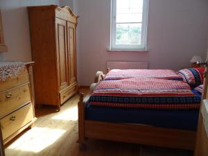 a bedroom with a bed and a dresser and a window at Holiday Home achtein by Interhome in Westoverledingen +21 photos