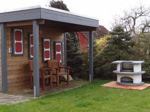 a gazebo with two chairs and a table in a yard at Holiday Home achtein by Interhome in Westoverledingen