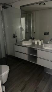 a bathroom with two sinks and a toilet and a mirror at Casa Douro in Valbom +12 photos
