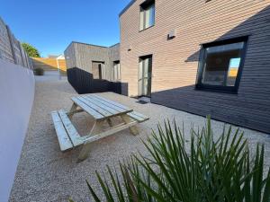 a picnic table sitting in front of a building at Lodges des Pontons - Cap Sud - vue mer in Saint-Côme-de-Fresné