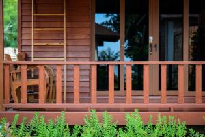 a porch of a house with a wooden railing at PingChan Koh Phangan Beachfront Resort in Thong Nai Pan Yai