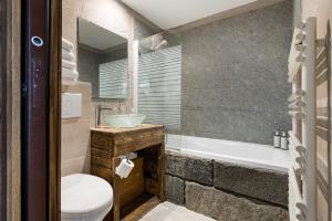 ein Badezimmer mit Waschbecken, Toilette und Badewanne in der Unterkunft Hôtel Vallée Blanche in Chamonix-Mont-Blanc + 46 Fotos