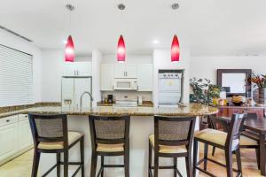 a kitchen with a large island with bar stools at Elegant Condo in High-End Resort Community with Pool and Beach Club Access in Coco