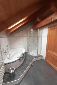 a bathroom with a tub and a walk in shower at Apartment Jutta by Interhome in Guttenberg