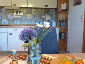 a vase with flowers on a table in a kitchen at Apartment FeWo Steinbeisser by Interhome in Arrach