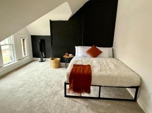 een slaapkamer met een bed met een zwart hoofdeinde bij Jungle House Columbus Short North Downtown Free Parking - Near Convention Center & Nationwide Arena - 4BR Luxury Home - Sleeps 12 - Over 5,800 Five Star Stays in Columbus