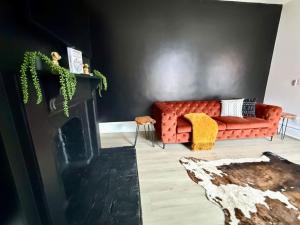 een woonkamer met een rode bank en een open haard bij Jungle House Columbus Short North Downtown Free Parking - Near Convention Center & Nationwide Arena - 4BR Luxury Home - Sleeps 12 - Over 5,800 Five Star Stays in Columbus