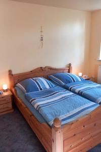 a bedroom with two beds with blue pillows at Apartment Mooij Plaats by Interhome in Großefehn 