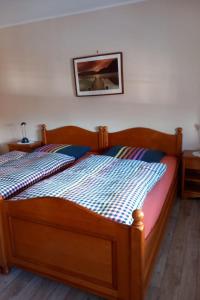 a wooden bed in a bedroom with a picture on the wall at Apartment Mooij Plaats by Interhome in Großefehn 