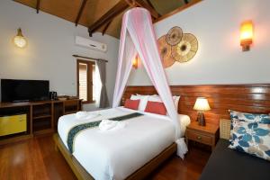 a bedroom with a bed with a mosquito net at PingChan Koh Phangan Beachfront Resort in Thong Nai Pan Yai