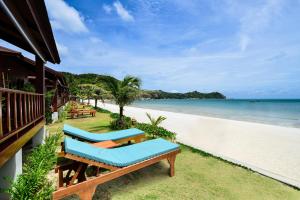 a beach with two lounge chairs and the ocean at PingChan Koh Phangan Beachfront Resort in Thong Nai Pan Yai