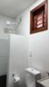 een keuken met witte muren en een spiegel aan de muur bij Suíte privativa 2 com Ar e Frigobar Casa Full Hausi in Fortim