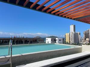 a swimming pool on the roof of a building at Stylish Condo Steps to Beach & Malecón in Mazatlán