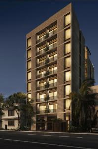 a tall apartment building with lights on at Stylish Condo Steps to Beach & Malecón in Mazatlán