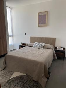 a bedroom with a large bed in a white room at Stylish Condo Steps to Beach & Malecón in Mazatlán +53 photos