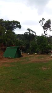 een groene tent in het midden van een veld bij Caveira oficiall in Mairiporã