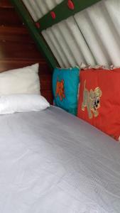 een bed met witte lakens en kussens in een kamer bij Caveira oficiall in Mairiporã