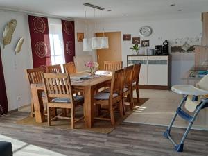 a kitchen and dining room with a wooden table and chairs at Apartment FeWo Steinbeisser by Interhome in Arrach