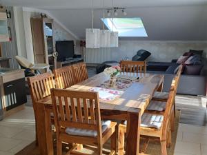 a wooden dining room table with chairs and a couch at Apartment FeWo Steinbeisser by Interhome in Arrach