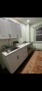 eine Küche mit weißen Schränken und einer Spüle und einem Fenster in der Unterkunft Must-See Okemo Mountain Resort in Springfield