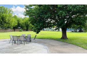 a table and chairs under a tree in a park at Regency Inn & Suites Houston East I 10 in Houston +21 photos