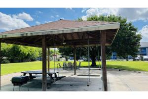 a pavilion with a picnic table and a swing at Regency Inn & Suites Houston East I 10 in Houston